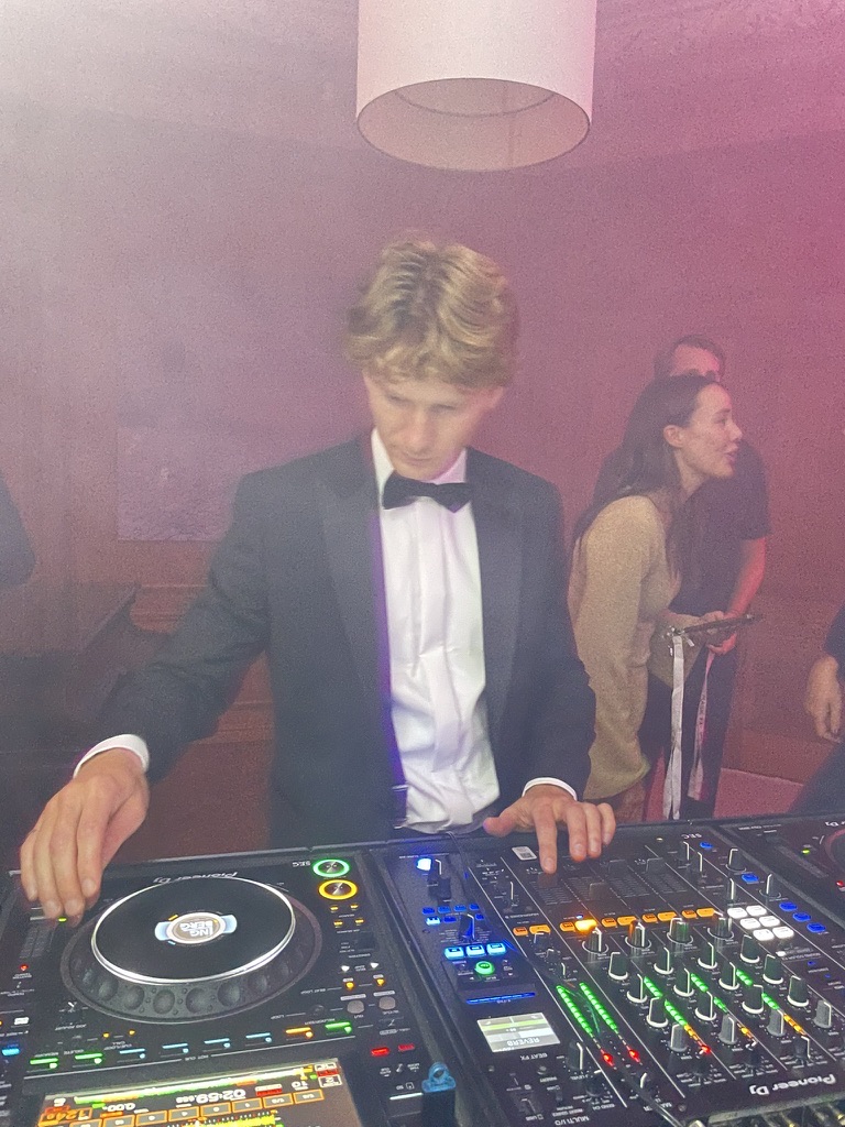 DJ i smoking vid ett Pioneer-bord på en fest